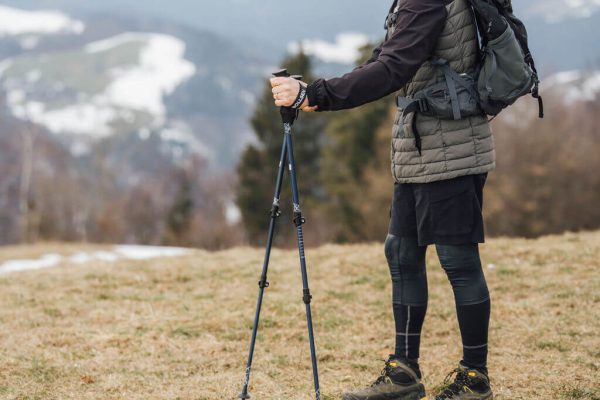 muž stojící s výzkumnými hůlkami Alpine Explorer