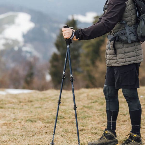 muž stojící s výzkumnými hůlkami Alpine Explorer